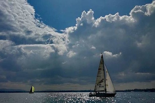 Sailing boat with big clouds on the background